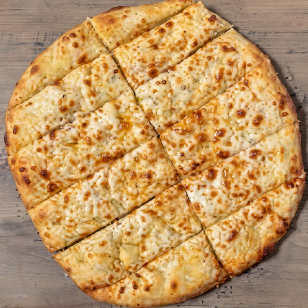 Round cheesy breadsticks, golden brown and cut into strips, on a rustic wooden table.
